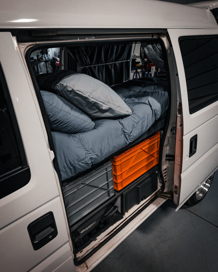 SidioCrate gray and orange storage crates mounted under a bed in a camper van.