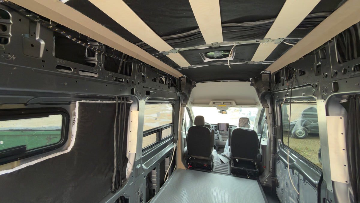 Empty camper van interior with insulated walls and ceiling furring strips ready for a conversion