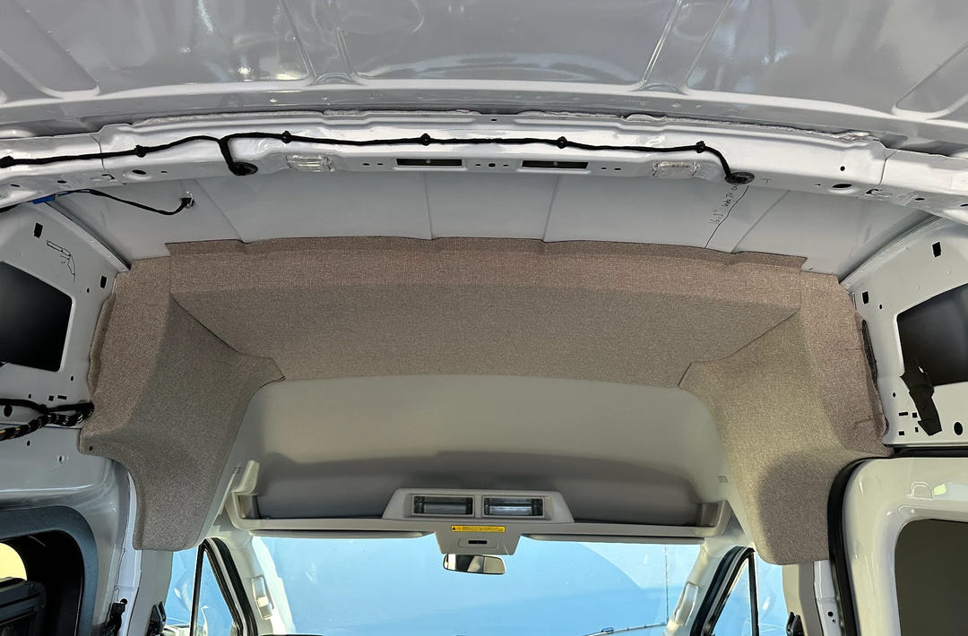 Grey fabric GoCode B pillar and ceiling insulation panel installed in a Ford Transit high roof van.